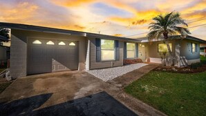 A two-story house with a garage, a covered patio, and a palm tree. - Spacious home With Heated Pool 3 miles from IMG! (Bradenton)