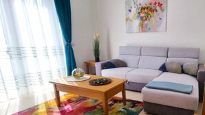 Ein modernes Wohnzimmer mit einer Couch, einem Couchtisch und einem farbenfrohen Teppich.