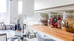 A kitchen counter with three glass jars labeled with contents like "SUGAR" and "GARLIC".
