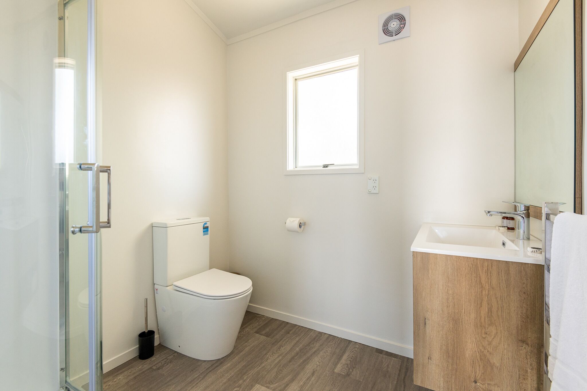 Un baño con inodoro, lavamanos y ventana.