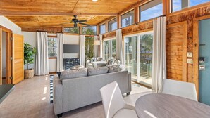 A modern living room with a sofa, chairs, and a dining table. - Dry Dock: Your Cozy Beachside Retreat at 612 Eastern Lake Rd (Seagrove Beach)