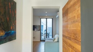 Um interior moderno com piso de madeira, um sofá azul claro e um quadro na parede.