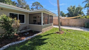 A single-story house with a covered porch, a brick foundation, and a fenced backyard. - Peaceful Beach Home Fully Equipped! (Sarasota)