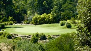 A golf course surrounded by dense trees and greenery. - Stylish Retreat in Macquarie Links - Golf, Comfort & Tranquility (Macquarie Links)