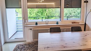 A room with a wooden table, two chairs, a radiator, and a window with blinds. - Seezugang & Ski Ossiacher See by Interhome (Bodensdorf)