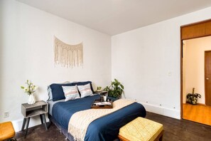 Restful retreat with a large bed, bedside table, and a decorative wall hanging.