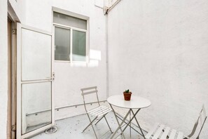 Enjoy a peaceful retreat in this serene outdoor space with a comfortable chair and a potted plant.
