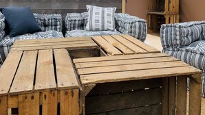 A cozy outdoor seating area with a wooden table and cushioned sofas, a wooden headboard, and a view of the landscape. - Starry Wigwam (pets not allowed) (MESSEY SUR GROSNE)
