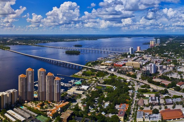 A coastal cityscape with a prominent bridge, high-rise buildings, and a marina. - 1449 Braman Ave (Fort Myers)