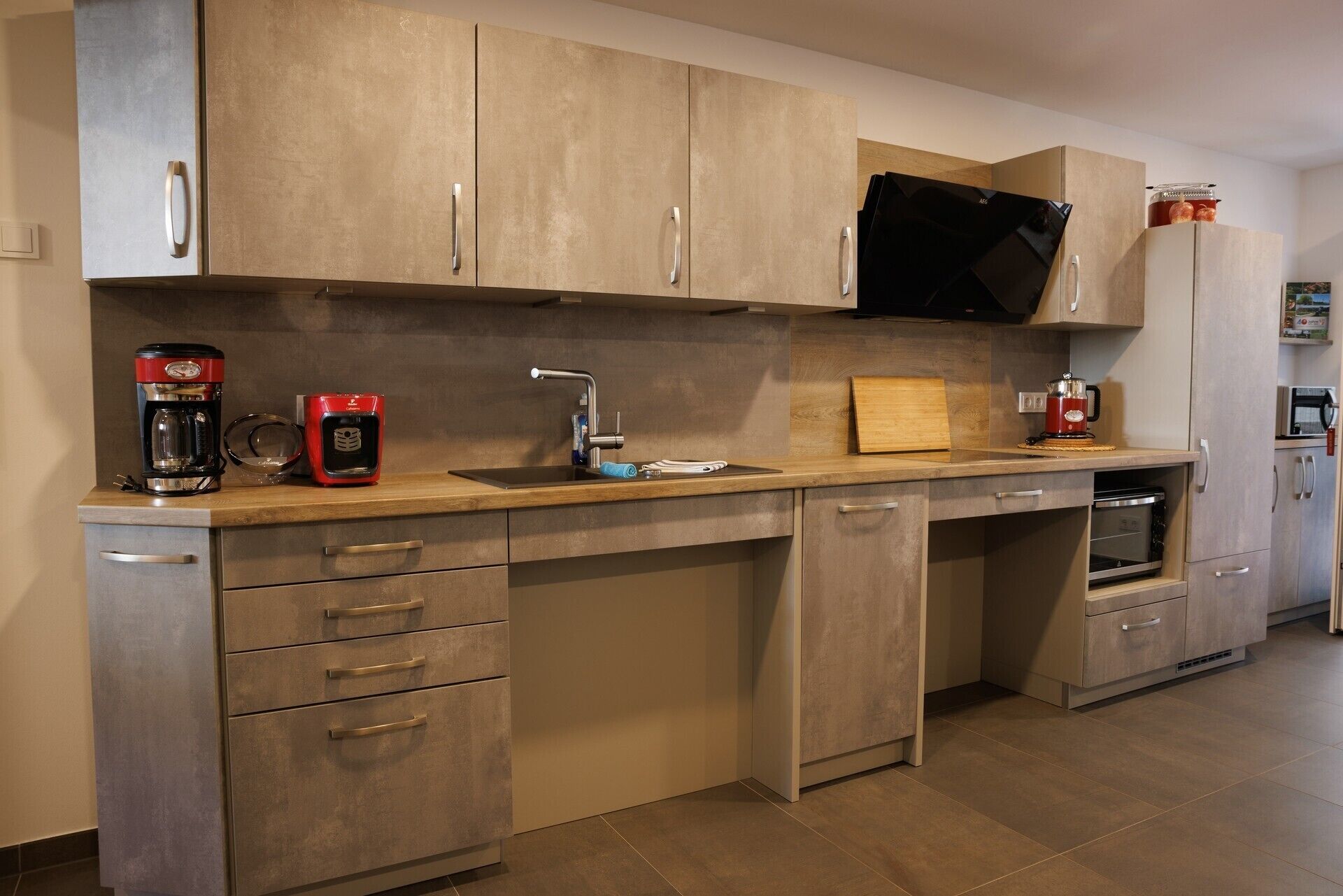 A modern kitchen with stainless steel appliances, a built-in oven, and a microwave.
