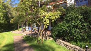 A pathway leading to a building with a stone wall and a grassy area. - Apartment "Waldeckchen" with Private Terrace & Wi-Fi (Waldeck)