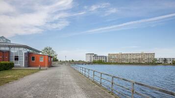 A waterfront walkway with a building on the left and a large apartment complex on the right.