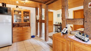 Eine Küche mit Holdekor, einem Kühlschrank und einer Essecke mit Tisch und Stühlen.