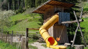 A wooden play structure with a slide and a small shelter. - Apartment 'Ferienwohnung 1' with Mountain View, Shared Terrace and Wi-Fi (Haslach im Kinzigtal)