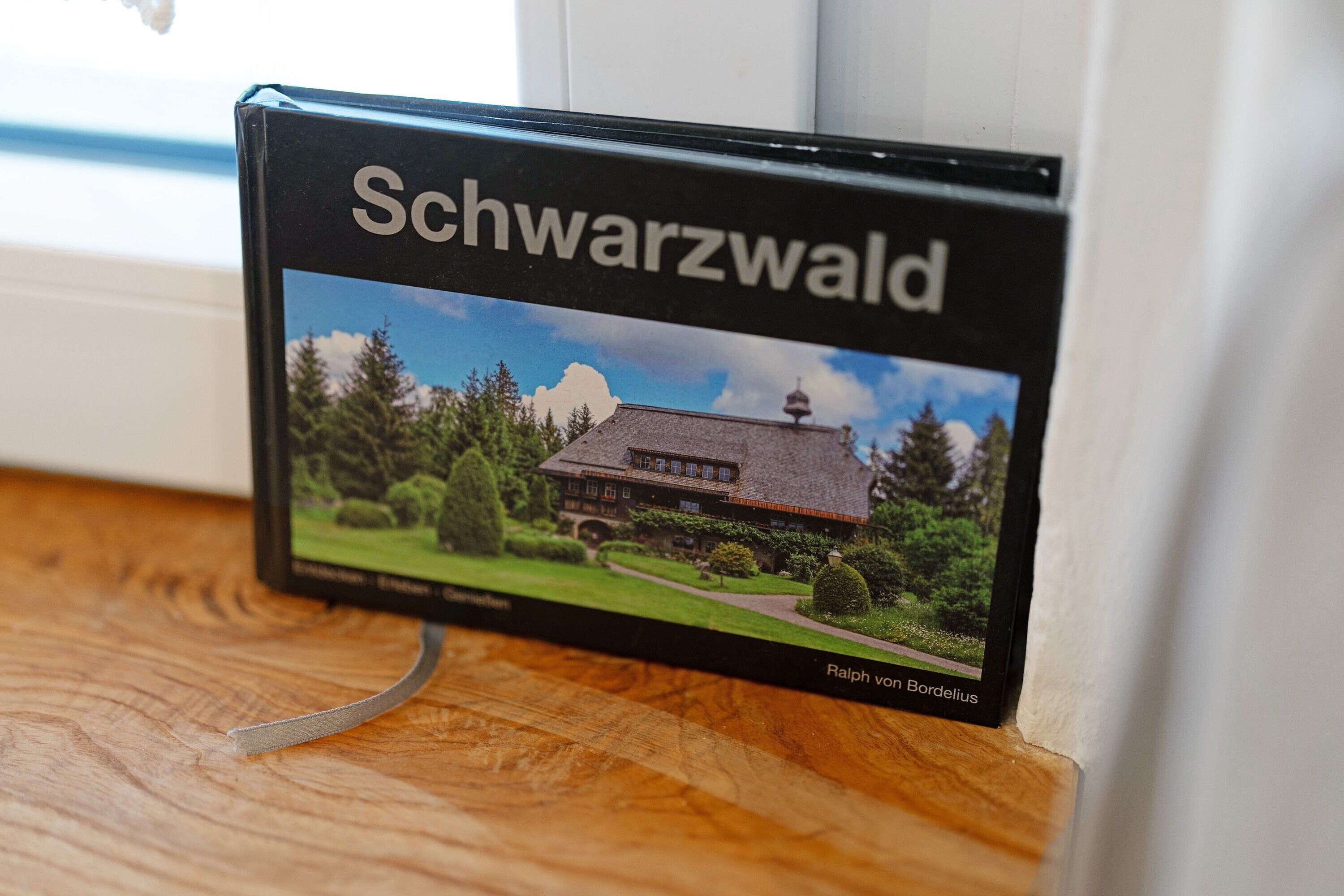A book titled 'Schwarzwald' with a picture of a house and trees.