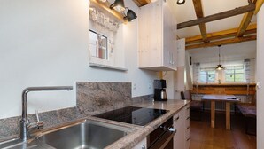 A kitchen with granite countertops, stainless steel sink, and wooden beams. - Apartment 'Ferienwohnung 2' with Mountain View, Shared Terrace and Wi-Fi (Haslach im Kinzigtal)