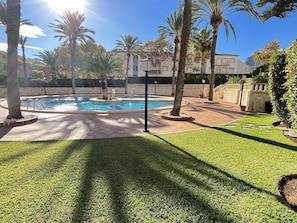 A swimming pool surrounded by palm trees and a well-maintained lawn. - Luxury flat for 4 people in Jávea (Xàbia)
