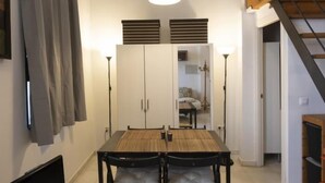 A dining area with a wooden table and black chairs, flanked by white cabinets and a ceiling light. - Dreams of the Sevilla Oasis in old town (Sevilla)