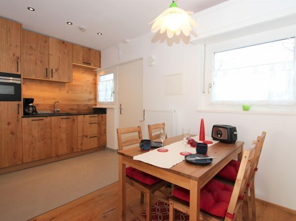 Enjoy meals in the kitchen with microwave and adjacent dining area with wooden table and chairs.