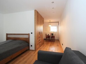Cozy retreat with a single bed, sofa, and dining area.
