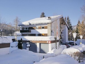 Two-story building with a flat roof, featuring large windows and a garage door.