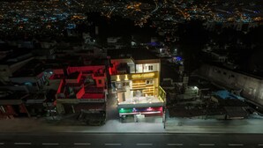 Un hôtel avec une enseigne indiquant « HÔTEL MAHADEV » et, en dessous, une autre enseigne indiquant « SMART POINT ».