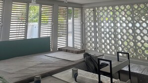 A room with large windows, a ceiling fan, and a white ceiling with recessed lighting.