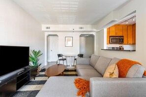 Relax in this stylish living room with a flat-screen TV, comfortable sofa, and a cozy coffee table.