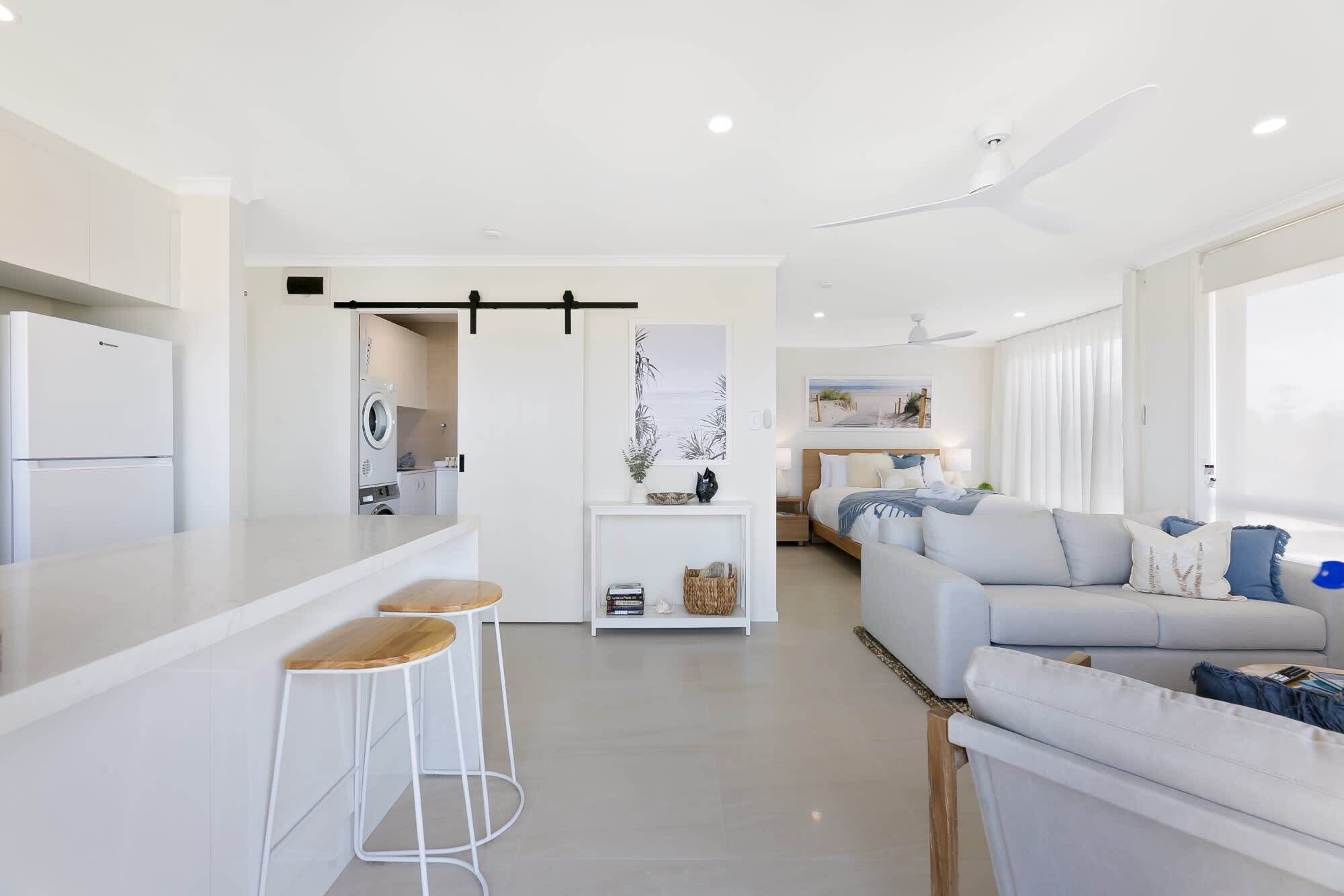 Un espace de vie moderne et ouvert, comprenant une cuisine, un coin repas et un grand canapé.