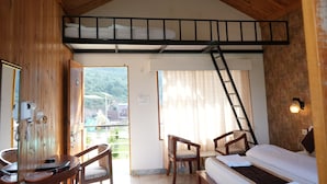 A room with a bunk bed, a desk with a chair, a ladder, and a view of the outdoors. - Resort Prakriti Unwind (Chakrata)