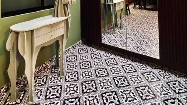 A room with patterned flooring, a table with chairs, and a decorative deer sculpture.