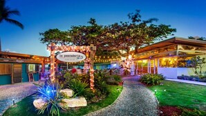 A well-lit outdoor area with a sign for 'la pesceria' restaurant, surrounded by greenery and a pathway. - 2Bed/2Bath at the Tennis Village at Palmas del Mar (Humacao)