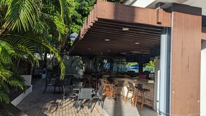 An outdoor seating area with tables and chairs, surrounded by greenery. - 2Bed/2Bath at the Tennis Village at Palmas del Mar (Humacao)