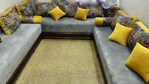 Un sofá de esquina con cojines estampados y una alfombra tejida.