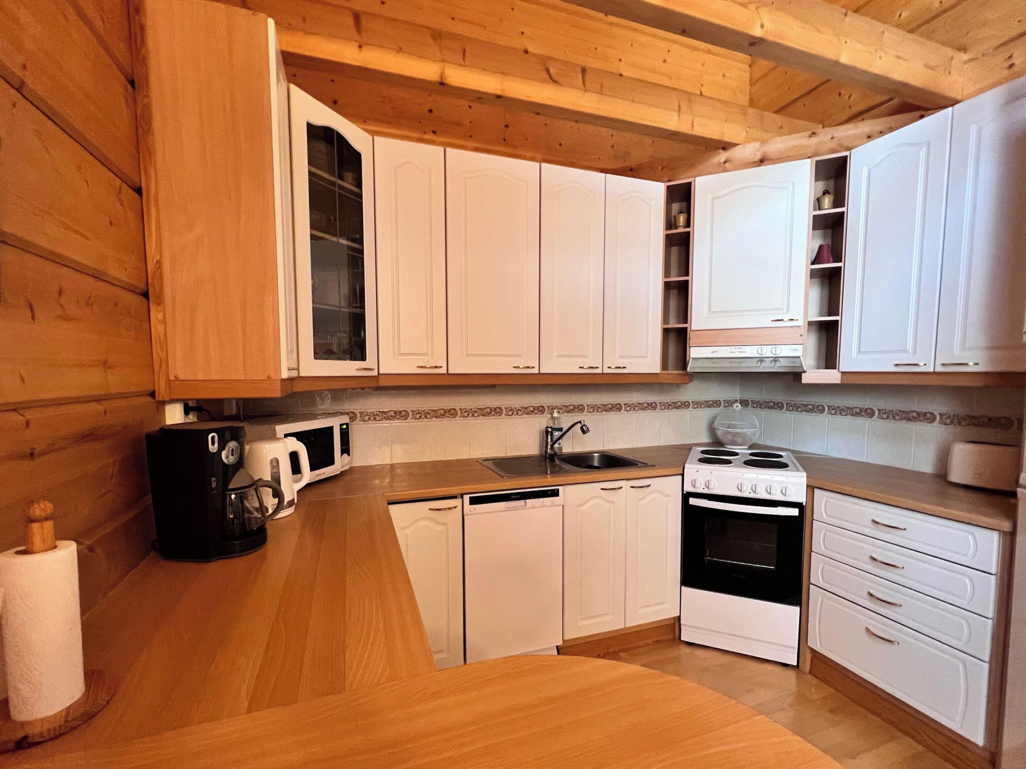 A kitchen with wooden cabinets, a microwave, a coffee maker, and a dishwasher.