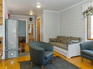 Ein gemütliches Wohnzimmer mit einem grauen Sofa, einem blauen Sessel und einem Holzboden.