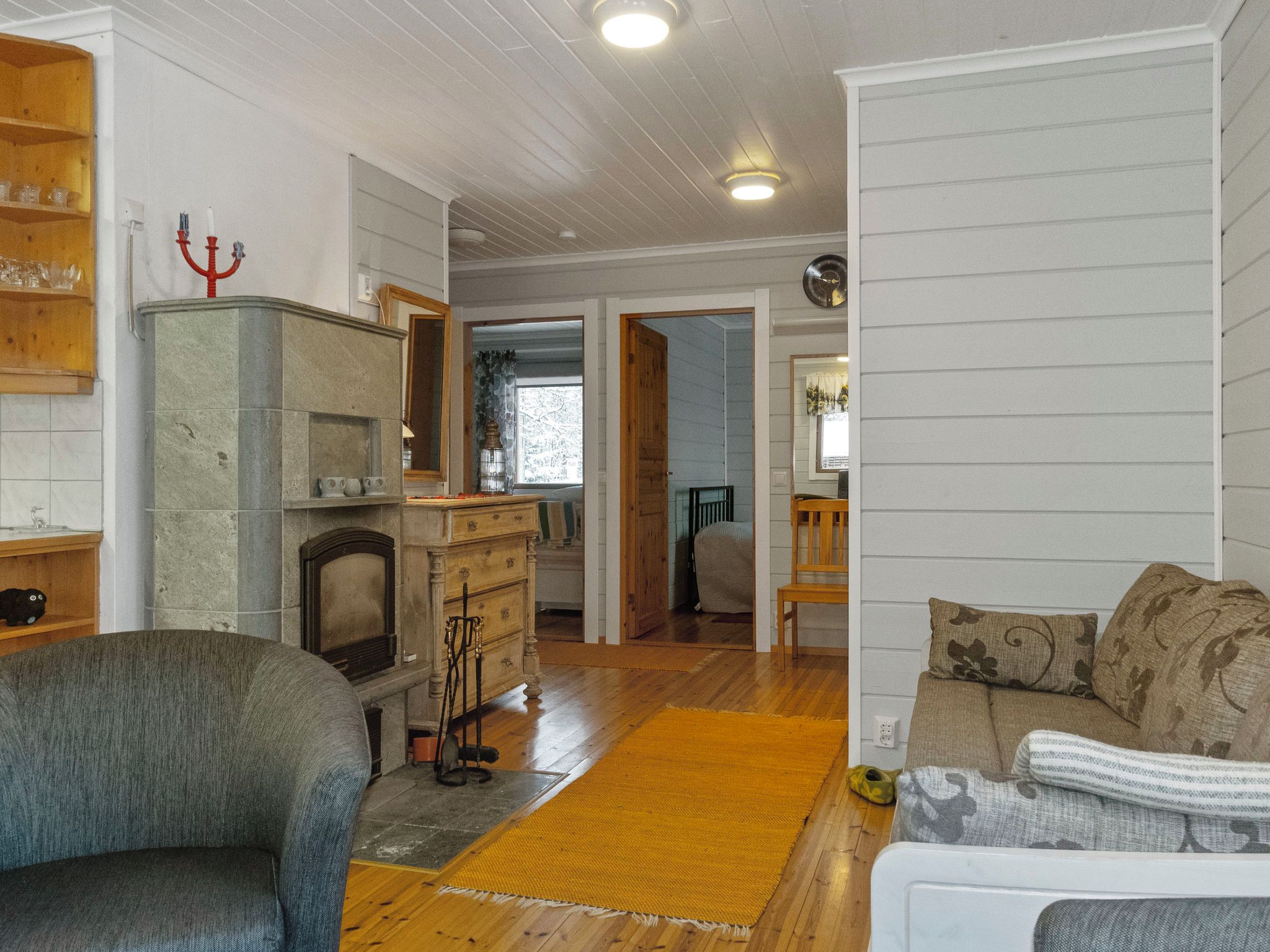 Ein Wohnzimmer mit Kamin, einer Couch, Holzboden und einem Essbereich im Hintergrund.