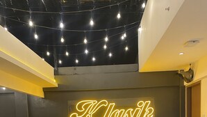 A restaurant interior with a neon sign reading "KlasiK", round tables, and black chairs. - Moonstar Cebu Hotel (Cebu City)