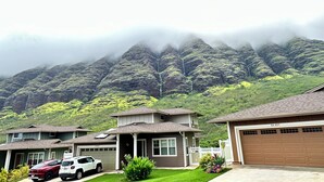 Quartiere residenziale con case, un garage e una montagna sullo sfondo.
