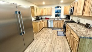 Une cuisine moderne avec des meubles en bois, des appareils en acier inoxydable et un plan de travail en granit.