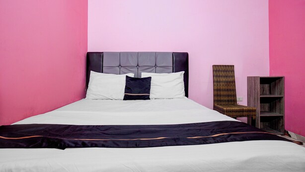 A bed with a headboard, pillows, and a blanket. - OYO Life 93342 Yasmine Guesthouse Syariah (Bandar Lampung)