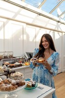 Montaje de bufé con diversos alimentos y una persona sirviendo.