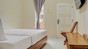 A bedroom with a bed, a wooden table, and a door.
