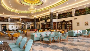 A spacious lobby with a grand chandelier, seating areas, a bar, and a staircase. - Eighty Eight Hotel and Spa (Tsaghkadzor)