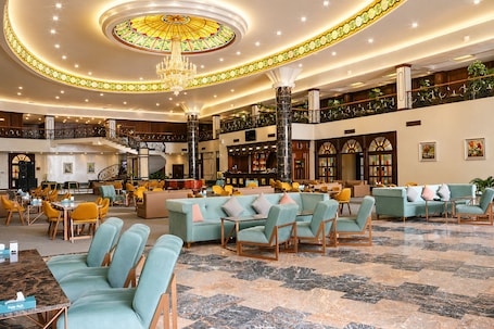 A spacious lobby with a grand chandelier, seating areas, a bar, and a staircase.. Eighty Eight Hotel and Spa