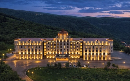 A large hotel with a central dome, multiple wings, and a well-lit facade.