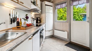 Eine moderne Küche mit weißen Schränken, einer Granit Arbeitsplatte und einem eingebauten Geschirrspüler. Ein Fenster bietet Blick auf Grünfläche.