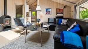 Ein gemütliches Wohnzimmer mit Kamin, Ledermöbeln und Kunstwerken an den Wänden.