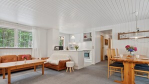 Un espace de vie moderne, ouvert et décloisonné, comprenant une cuisine, un coin repas et un espace salon.