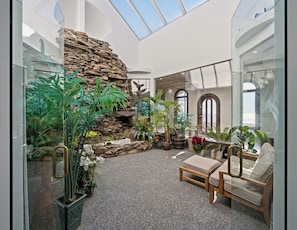 Sink into the leather sofa beside a stone fireplace, with an arched window opening to the water.